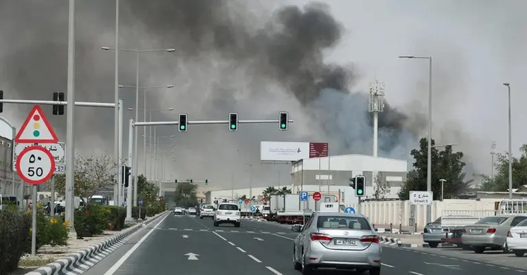 দোহায় একটি সড়কের দূরে কালো ধোঁয়া উঠতে দেখা যাচ্ছে
